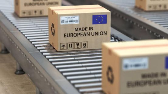 Kartons mit Text „Made in European Union“ und EU-Flagge auf einem Rollenband.